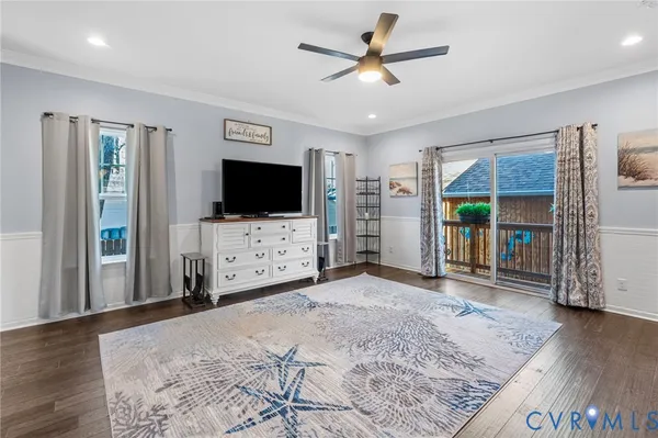 a view of a livingroom with a flat screen tv wooden floor and a ceiling fan