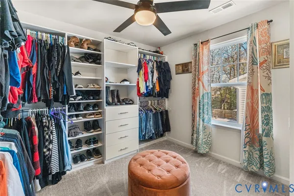 a view of walk in closet with clothes and shoes