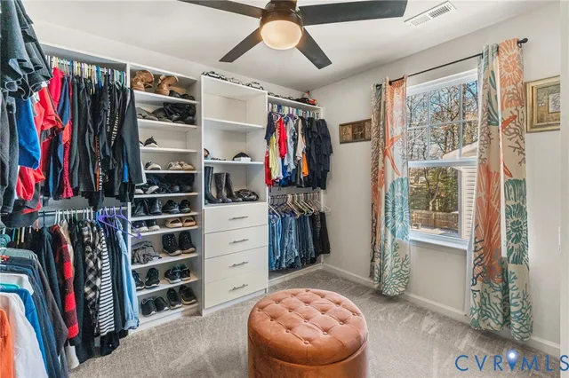 a view of walk in closet with clothes and shoes