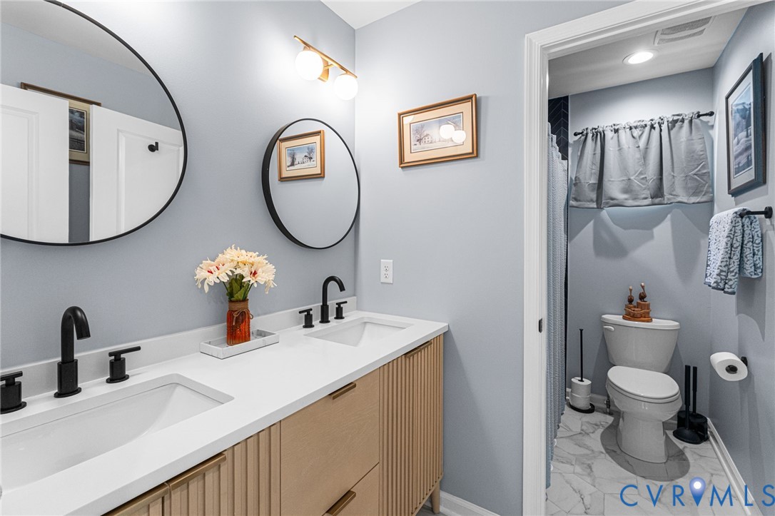 123 8th Street Colonial Beach, VA 22443 - Photo 29 of 40 a bathroom with a toilet sink vanity and mirror