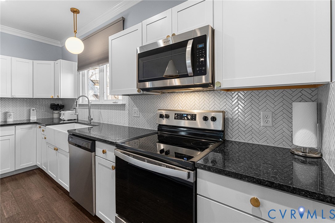 123 8th Street Colonial Beach, VA 22443 - Photo 8 of 36 a kitchen with stainless steel appliances granite countertop a sink a stove a microwave and cabinets
