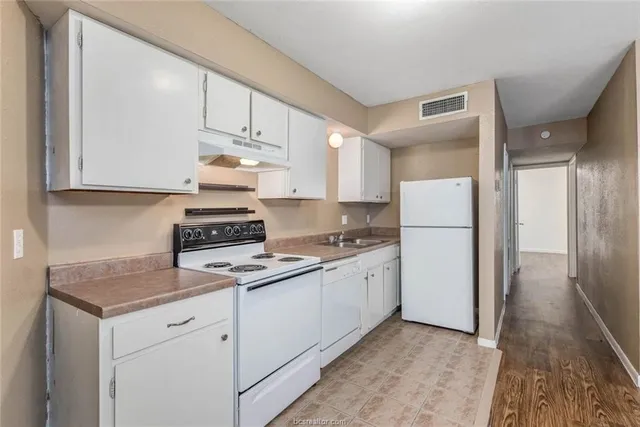 a kitchen with appliances a sink and cabinets