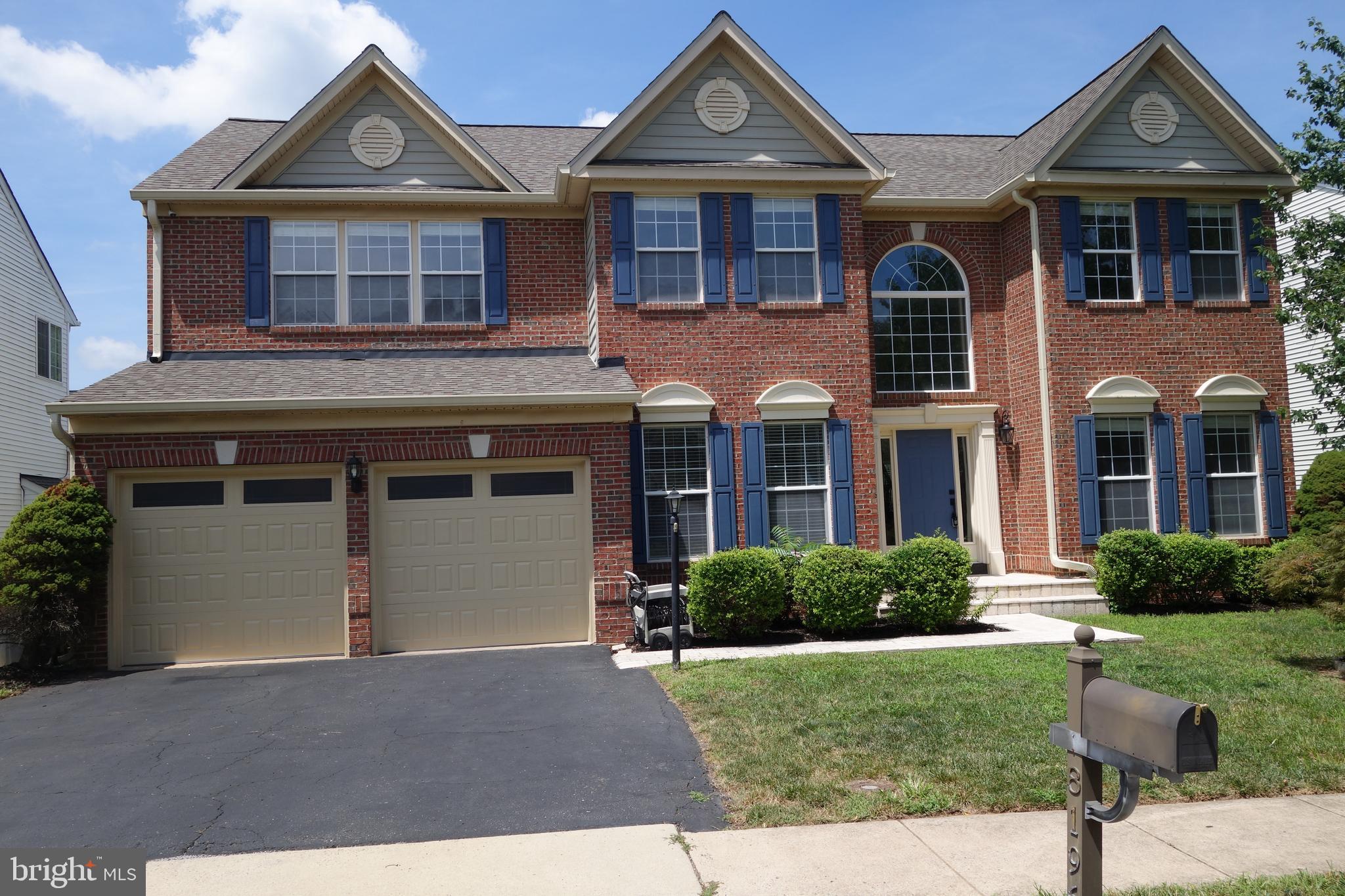 a front view of a house with porch and garden