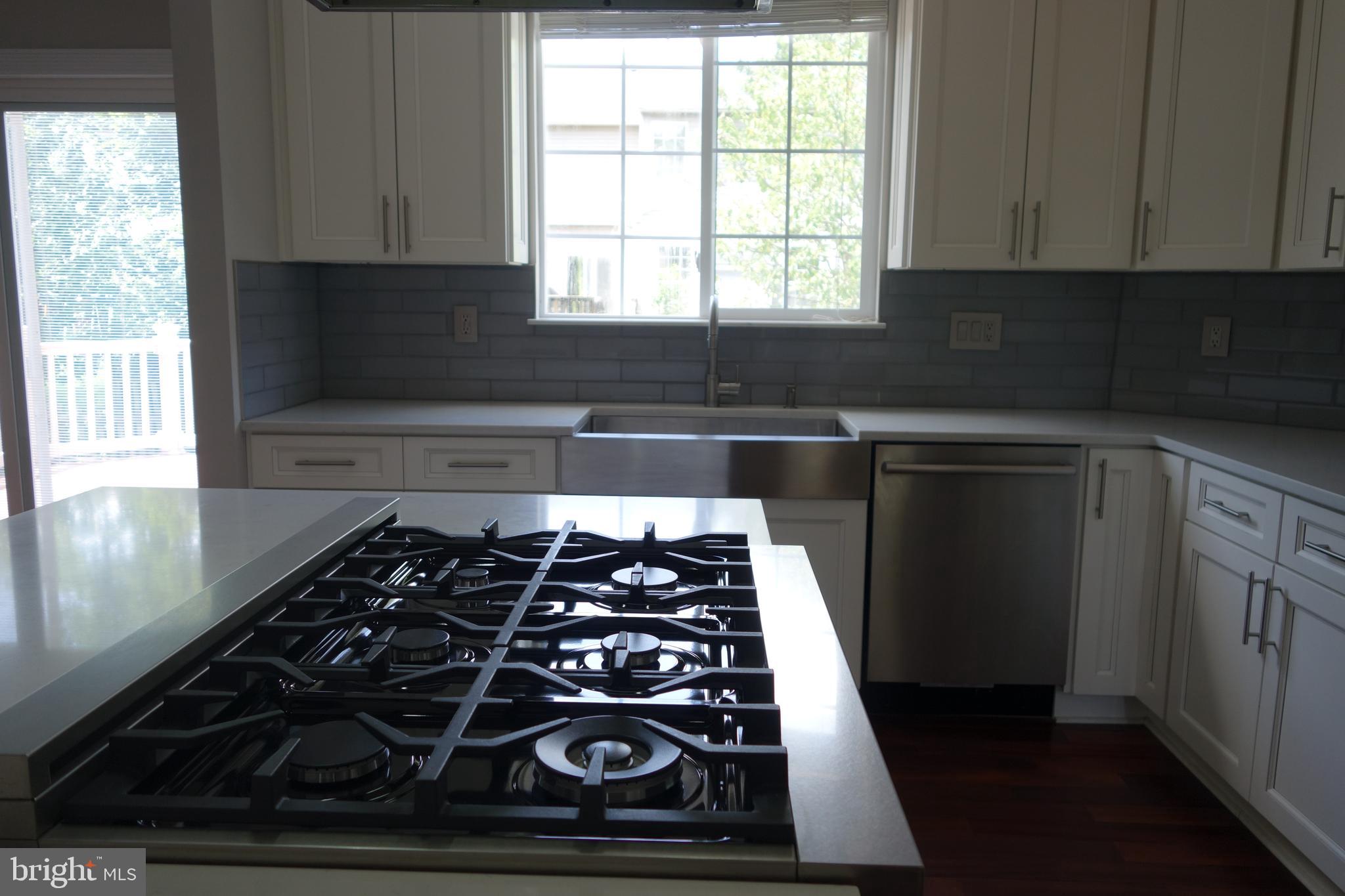 8196 Tenbrook Drive Gainesville, VA 20155 - Photo 16 of 51 a kitchen with wooden cabinets and a stove