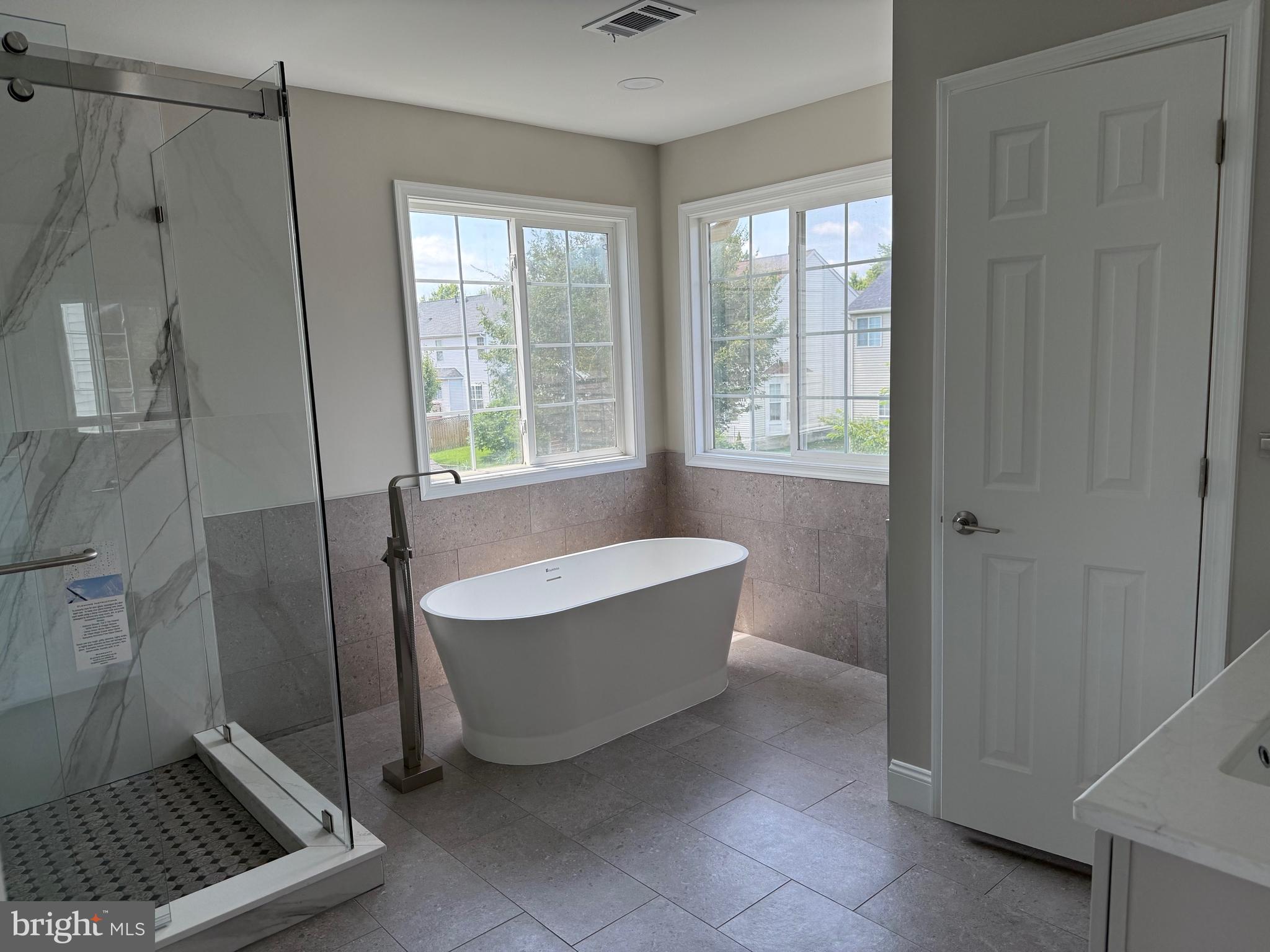 8196 Tenbrook Drive Gainesville, VA 20155 - Photo 28 of 51 a bathroom with a tub a window and a shower
