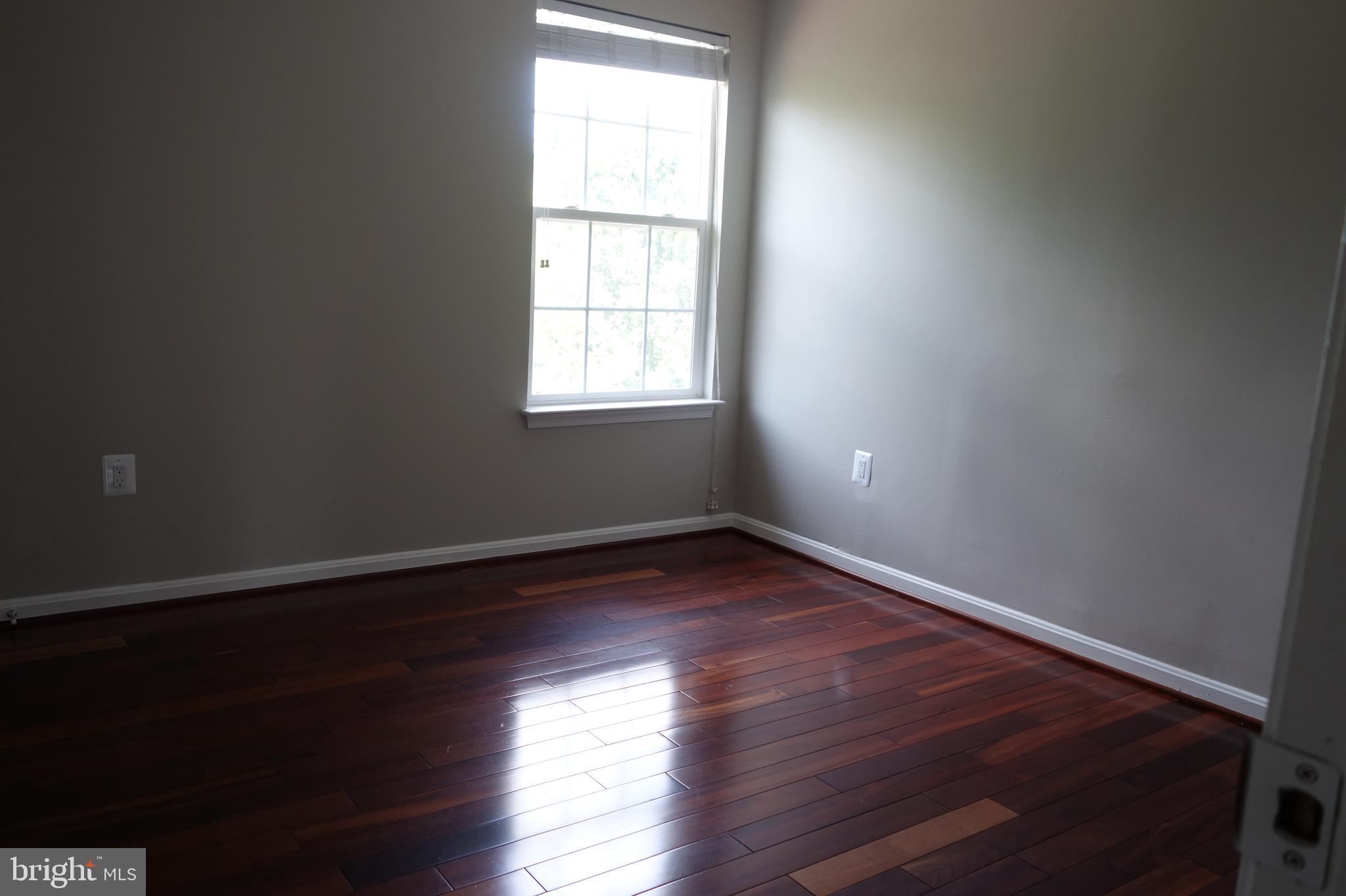 8196 Tenbrook Drive Gainesville, VA 20155 - Photo 35 of 51 an empty room with wooden floor and windows