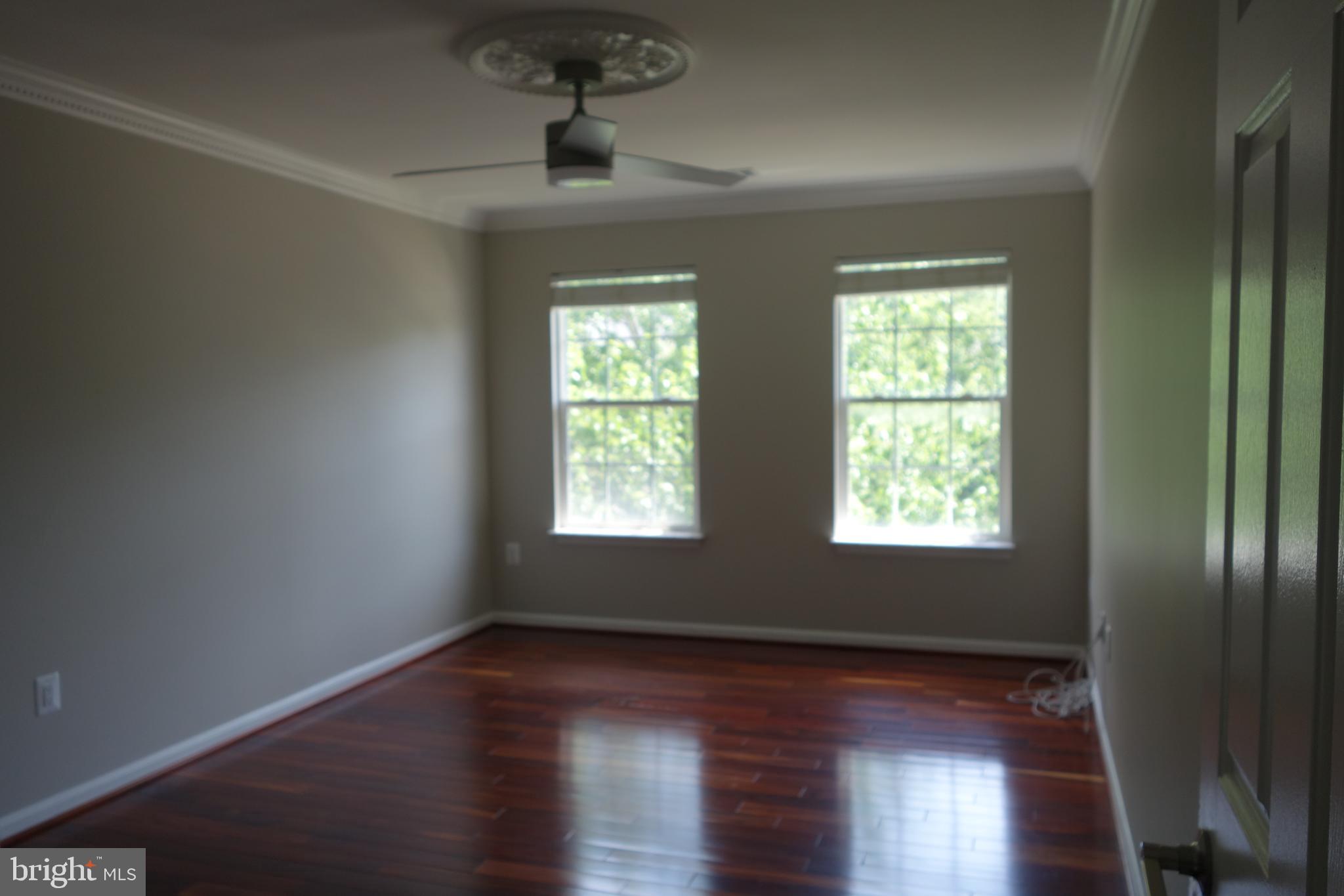 8196 Tenbrook Drive Gainesville, VA 20155 - Photo 38 of 51 a view of an empty room with wooden floor and a window