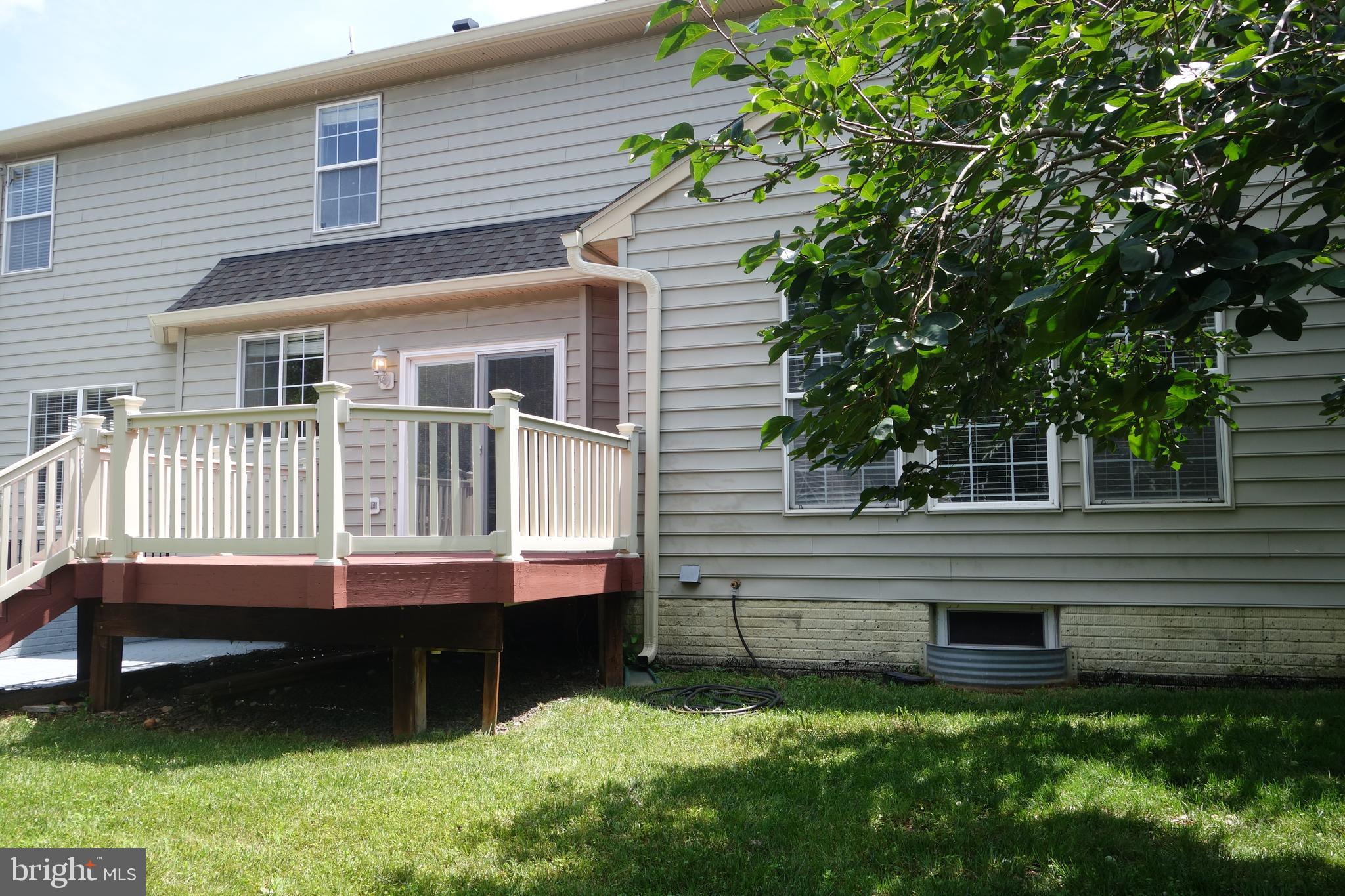 8196 Tenbrook Drive Gainesville, VA 20155 - Photo 50 of 51 a view of a house with a wooden deck and a yard