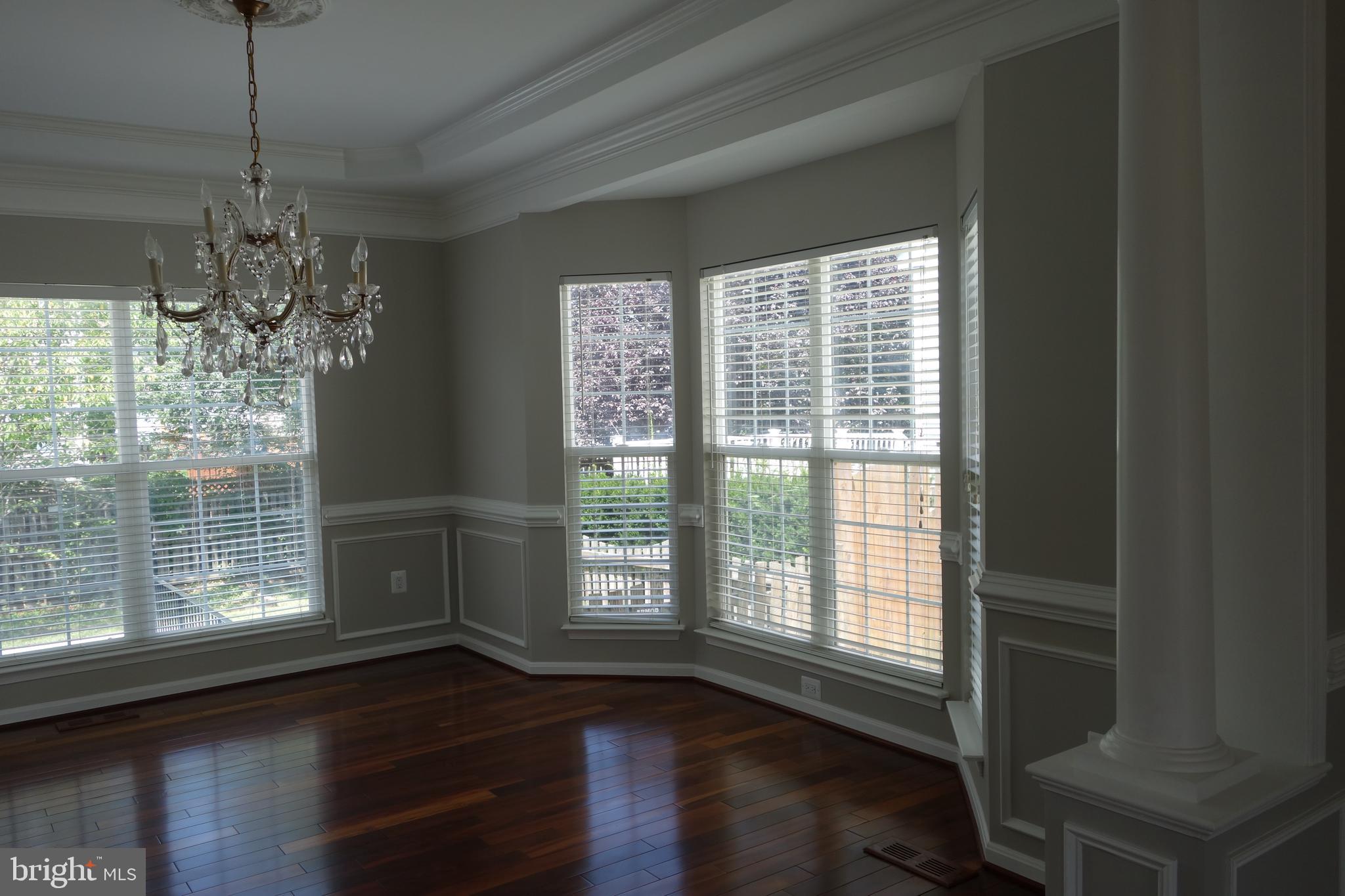8196 Tenbrook Drive Gainesville, VA 20155 - Photo 9 of 51 a room with wooden floor large windows and a chandelier
