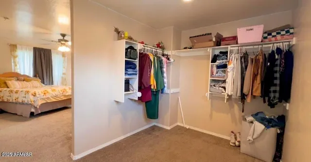 a view of walk in closet with clothes and shoes