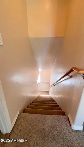 a view of an empty room and chandelier fan