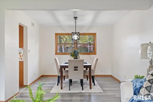a dining room with furniture a chandelier and wooden floor