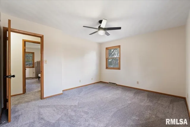 a view of an empty room with window and bathroom