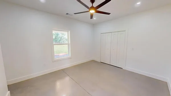 an empty room with a window and a fan