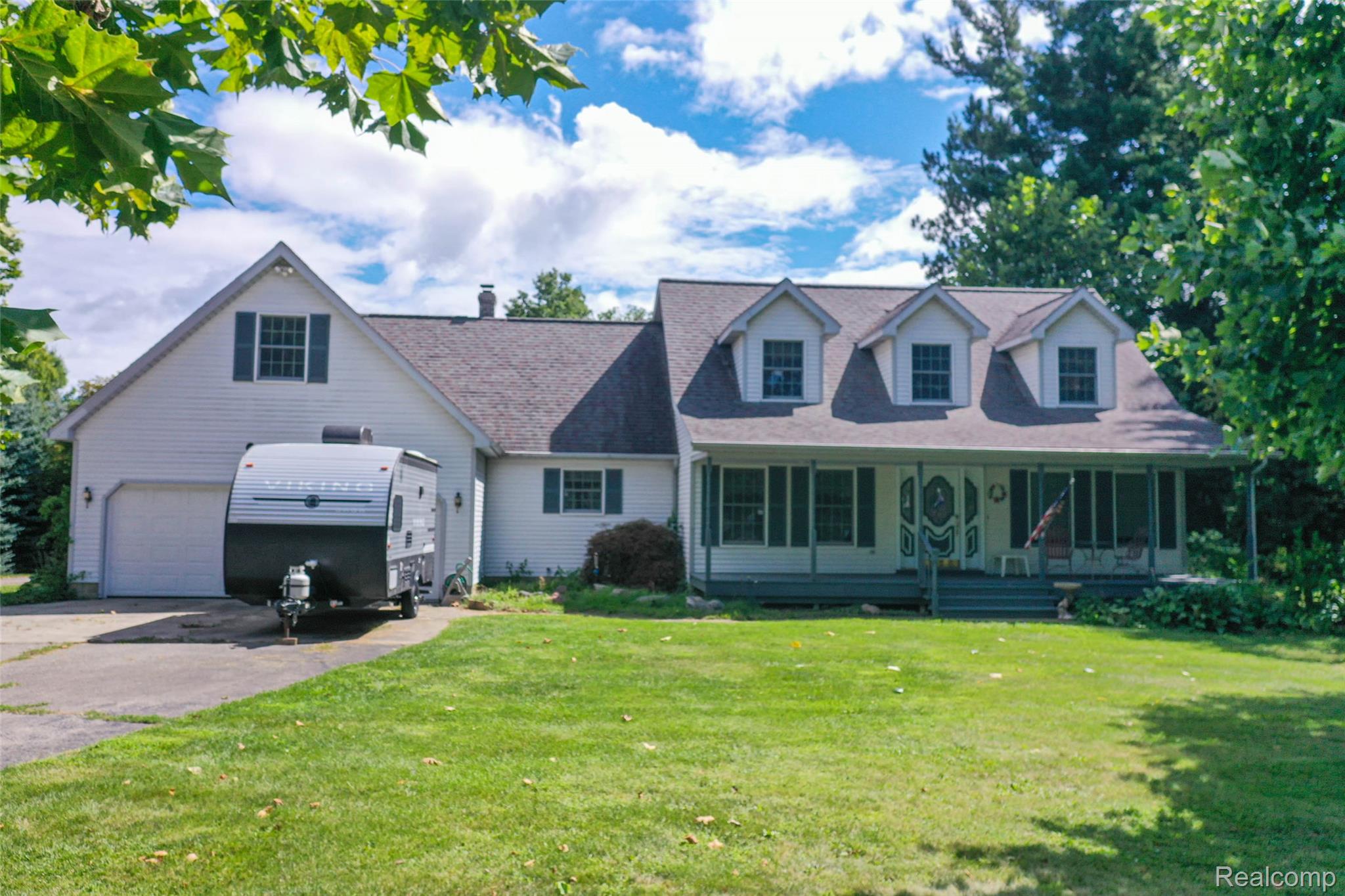 1591 Baldwin Road Lapeer, MI 48446 - Photo 1 of 46 Cape cod house with concrete driveway, a porch, and a front yard