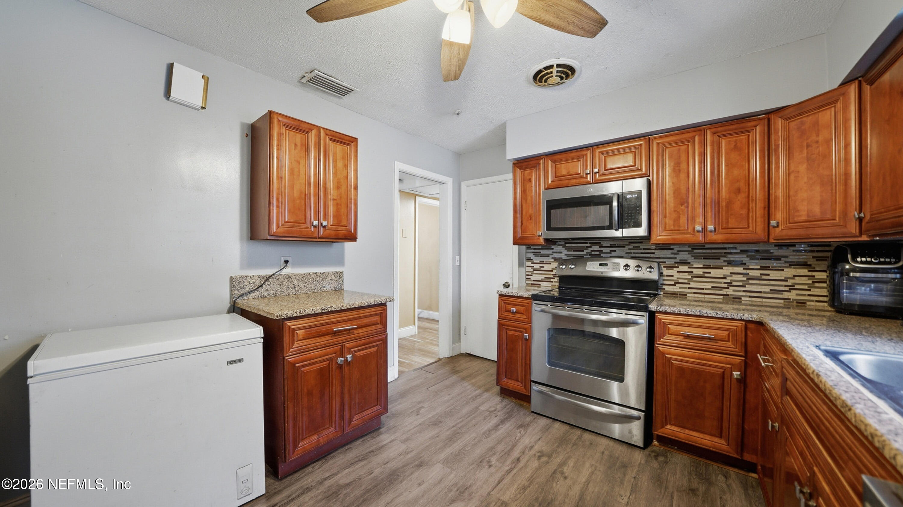 2238 Ligustrum Road Jacksonville, FL 32211 - Photo 13 of 31 a kitchen with stainless steel appliances granite countertop a stove a sink and a microwave