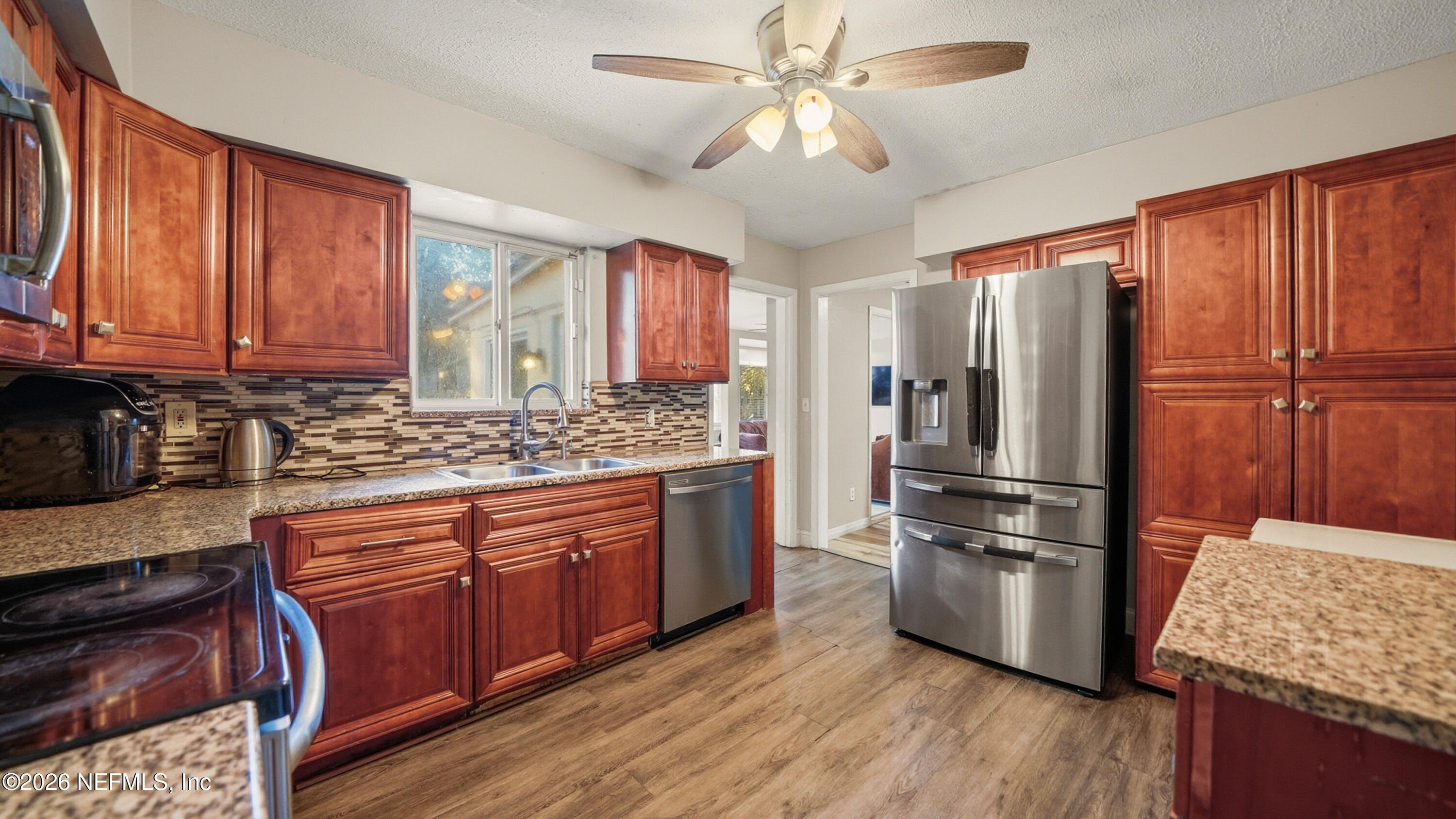 2238 Ligustrum Road Jacksonville, FL 32211 - Photo 6 of 31 a kitchen with stainless steel appliances granite countertop a refrigerator a stove a sink dishwasher and wooden cabinets with wooden floor