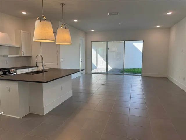 a kitchen with granite countertop a sink a counter top space and cabinets