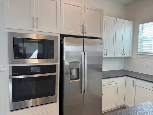 a kitchen with cabinets and a refrigerator