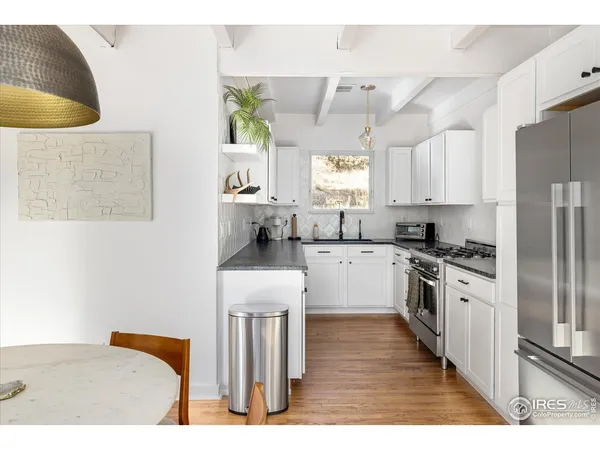 a kitchen with stainless steel appliances granite countertop a sink a stove a refrigerator and island