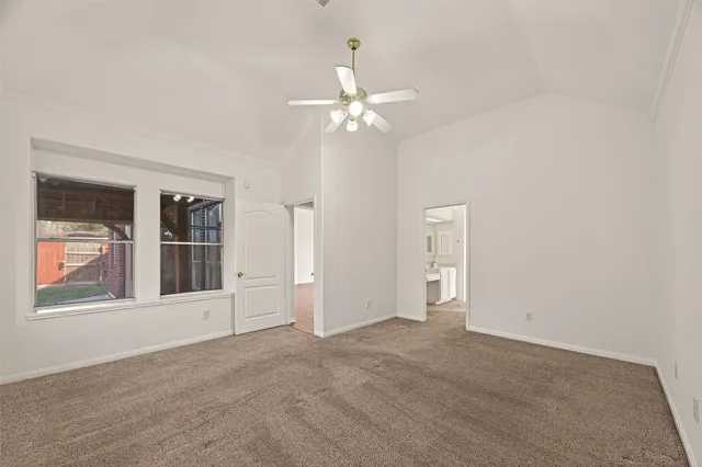 an empty room with windows and ceiling fan