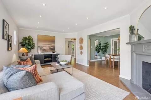 a dining room with furniture a large window and wooden floor