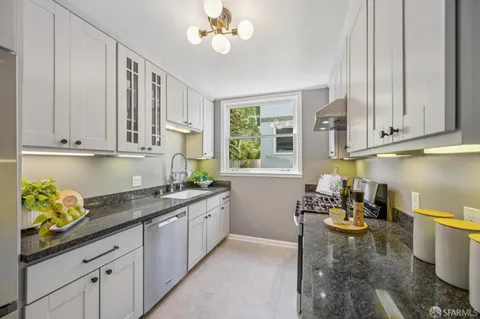 a kitchen with stainless steel appliances granite countertop a sink a stove and cabinets