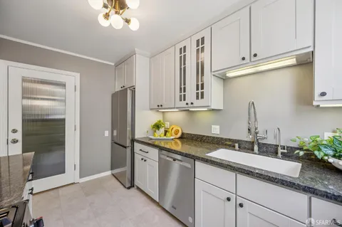 a bedroom with a bed a mirror and a large window