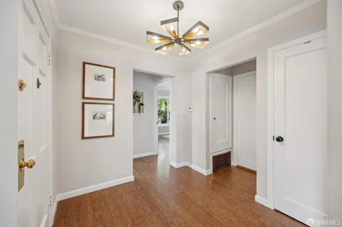 a bed sitting in a bedroom next to a window with a rug and a wooden floor