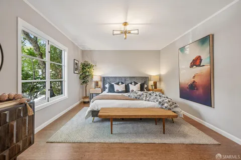 a bedroom with a bed and a large window