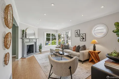 a living room with furniture a fireplace and a potted plant