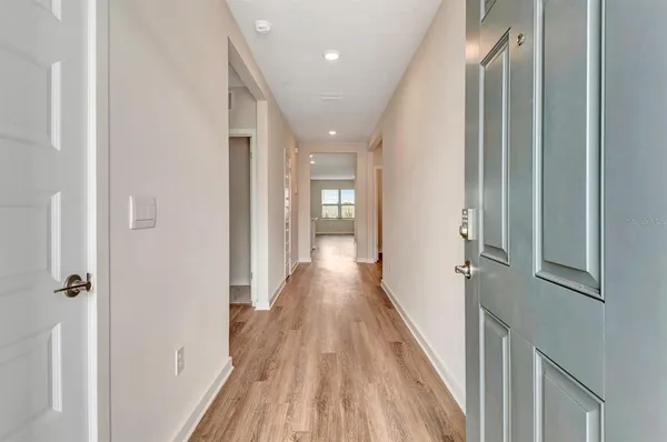 a view of a hallway with wooden floor and staircase