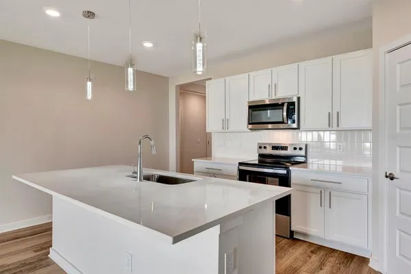 a kitchen with a stove a sink and a refrigerator