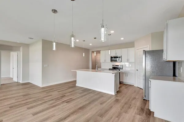 a kitchen with sink a microwave and cabinets