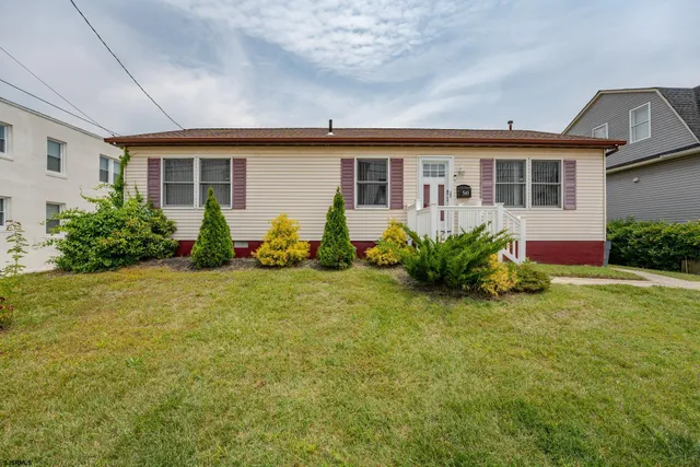 a front view of house with yard and outdoor seating