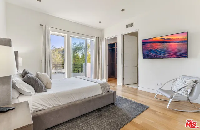a bedroom with a bed and glass door