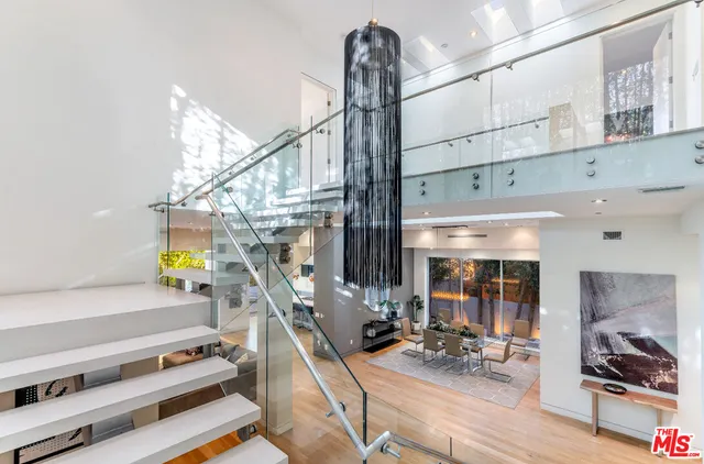 a view of gym equipment and living room with windows