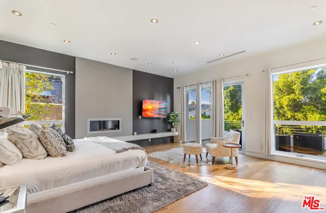 a bedroom with a bed and large windows with outer view