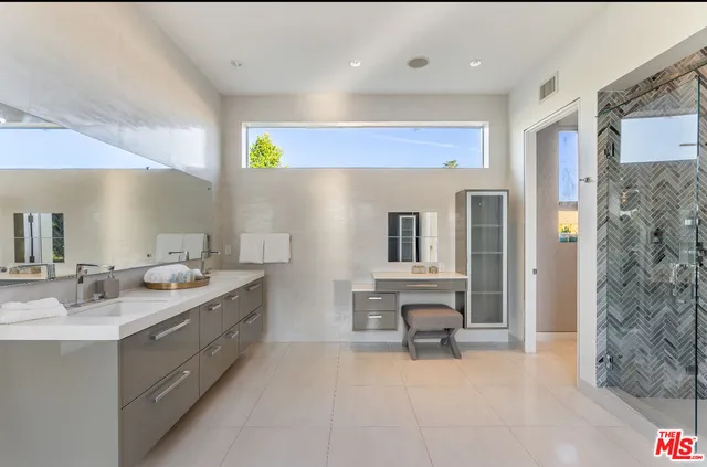 a spacious bathroom with a double vanity sink and a mirror