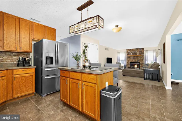 a kitchen with stainless steel appliances granite countertop a sink a stove and a refrigerator