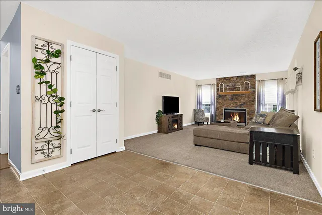 a living room with furniture a large window and a fireplace