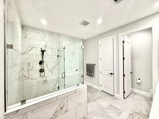 a bathroom with a shower and a glass door