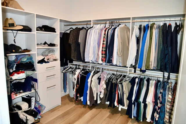 a view of walk in closet with clothes and shoes
