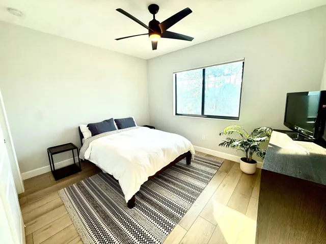 a bedroom with a bed and wooden floor