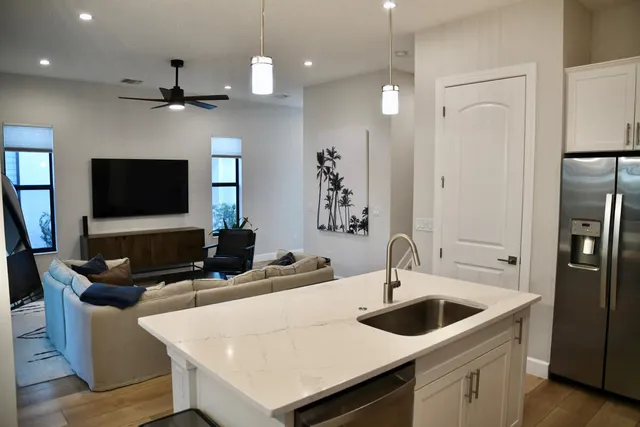 a kitchen with a sink a counter top space a refrigerator and a sink