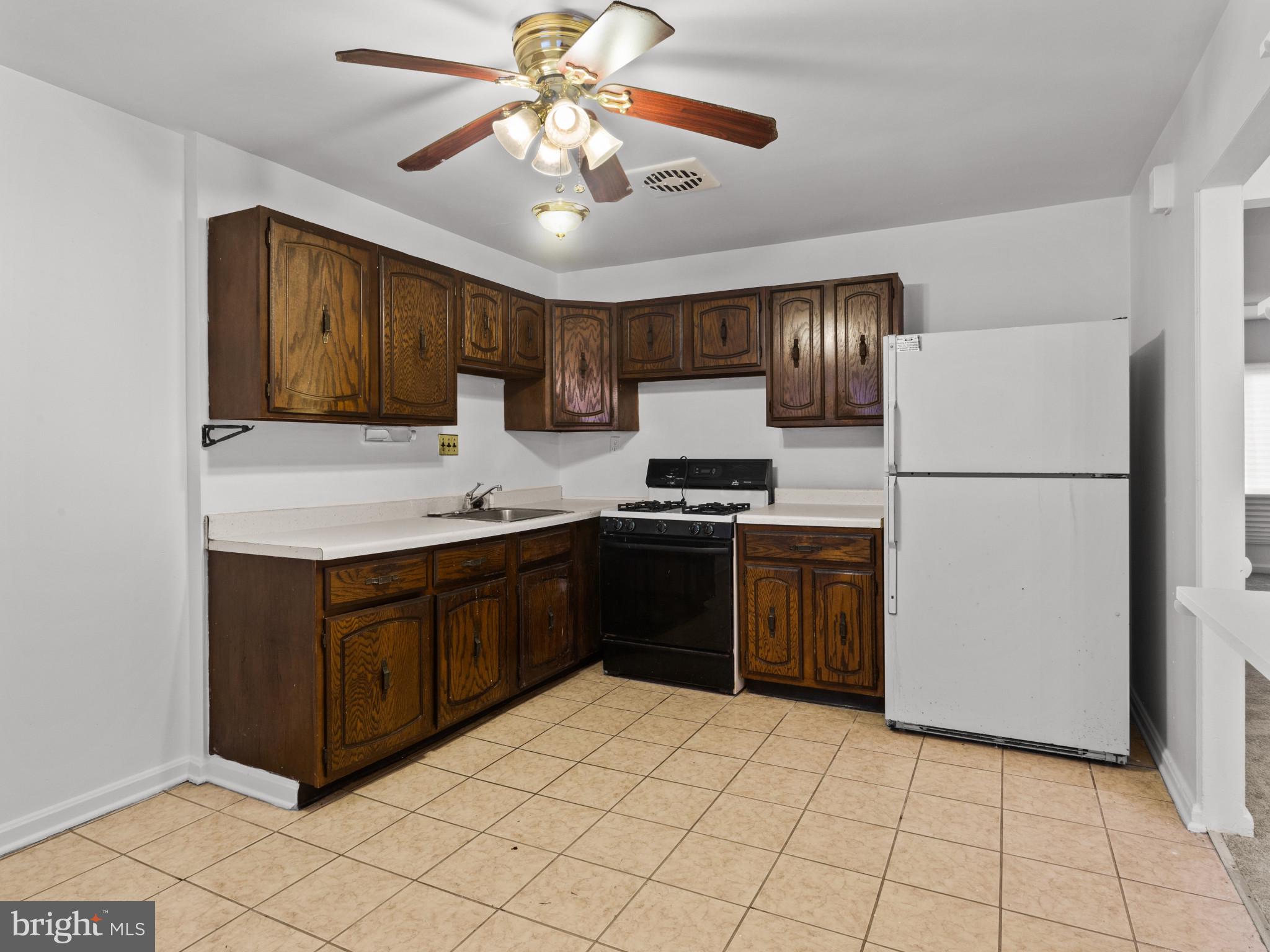 4008 24th Place Temple Hills, MD 20748 - Photo 15 of 31 a kitchen with a refrigerator cabinets and wooden floor