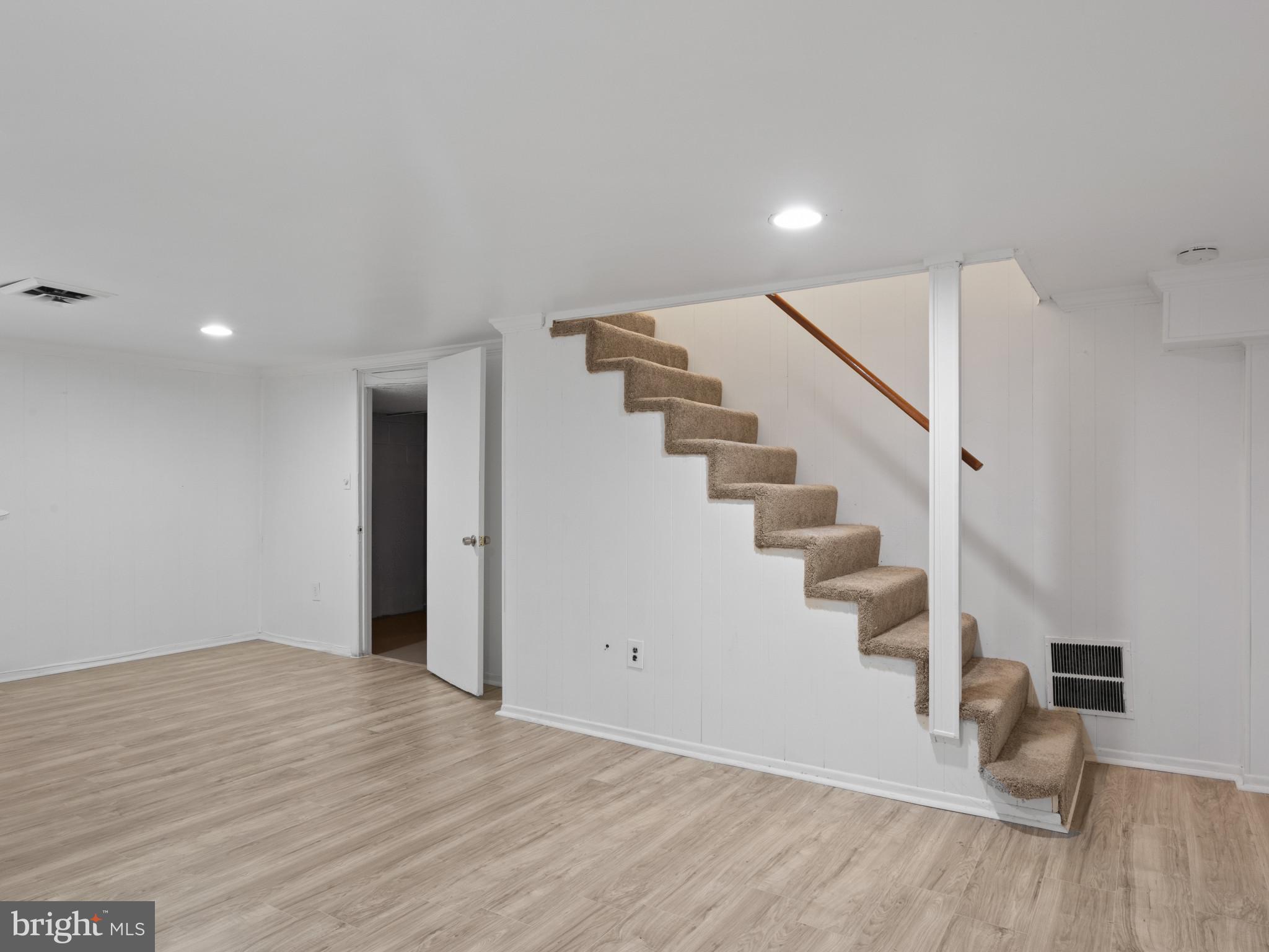 4008 24th Place Temple Hills, MD 20748 - Photo 26 of 31 a view of an empty room with wooden floor and stairs