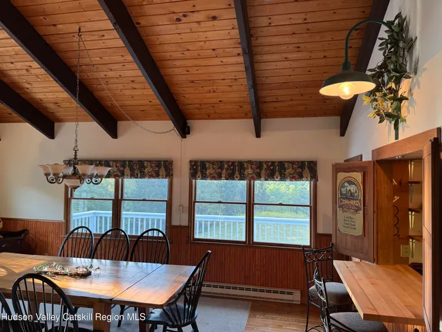 a dining room with stainless steel appliances granite countertop furniture a window and a kitchen view