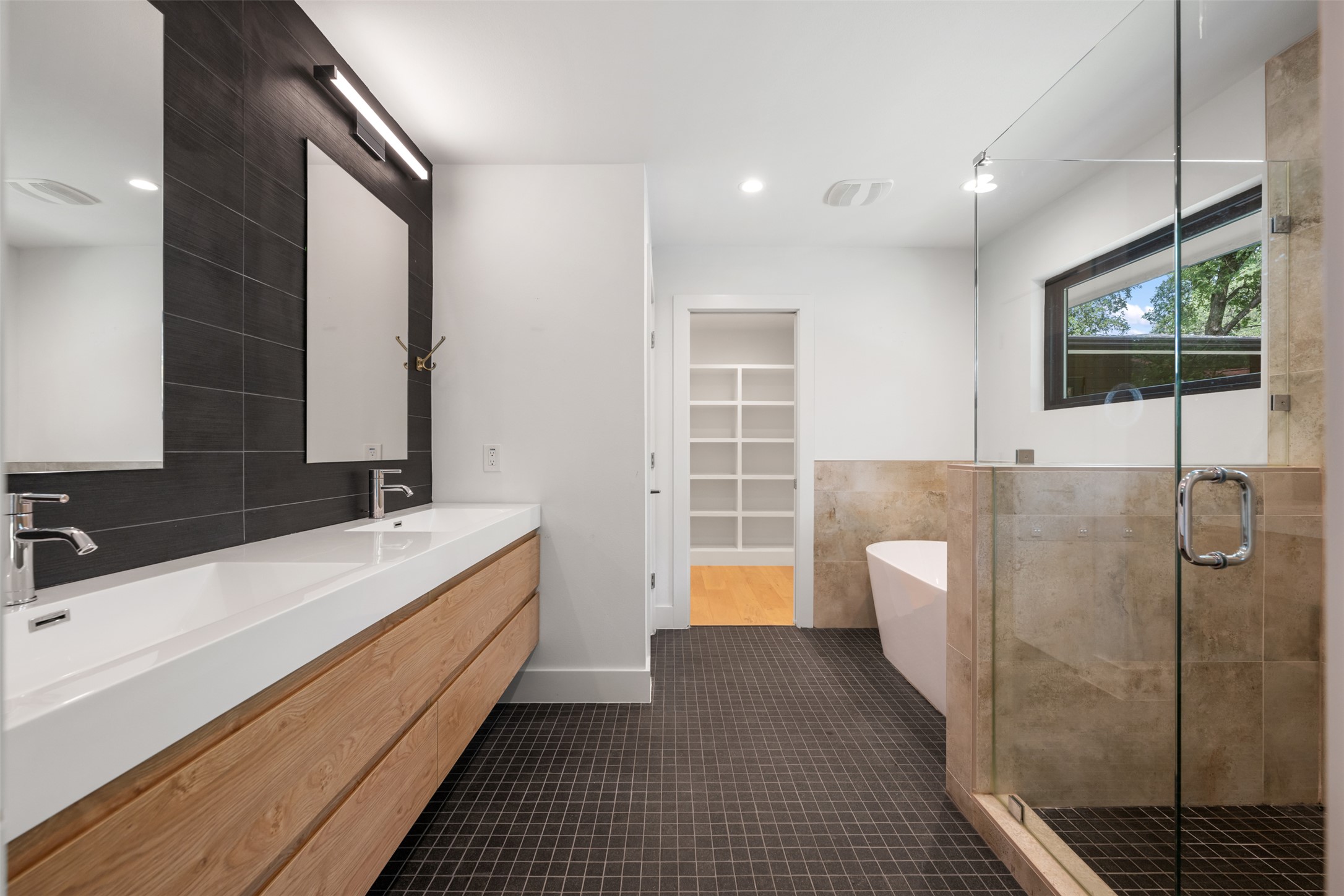 8900 Point W Drive Austin, TX 78759 - Photo 24 of 40 A sleek, contemporary primary bathroom features a floating double vanity and a glass-enclosed shower.