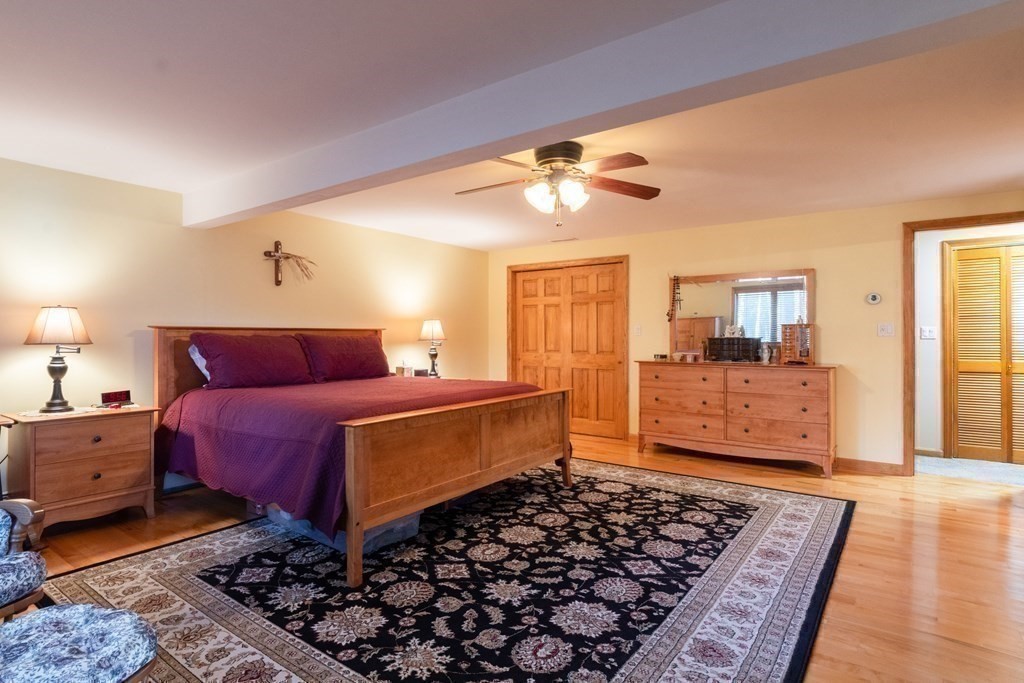 2 Rocky Hill Road Amherst, NH 03031 - Photo 13 of 36 a bedroom with a bed and wooden floor